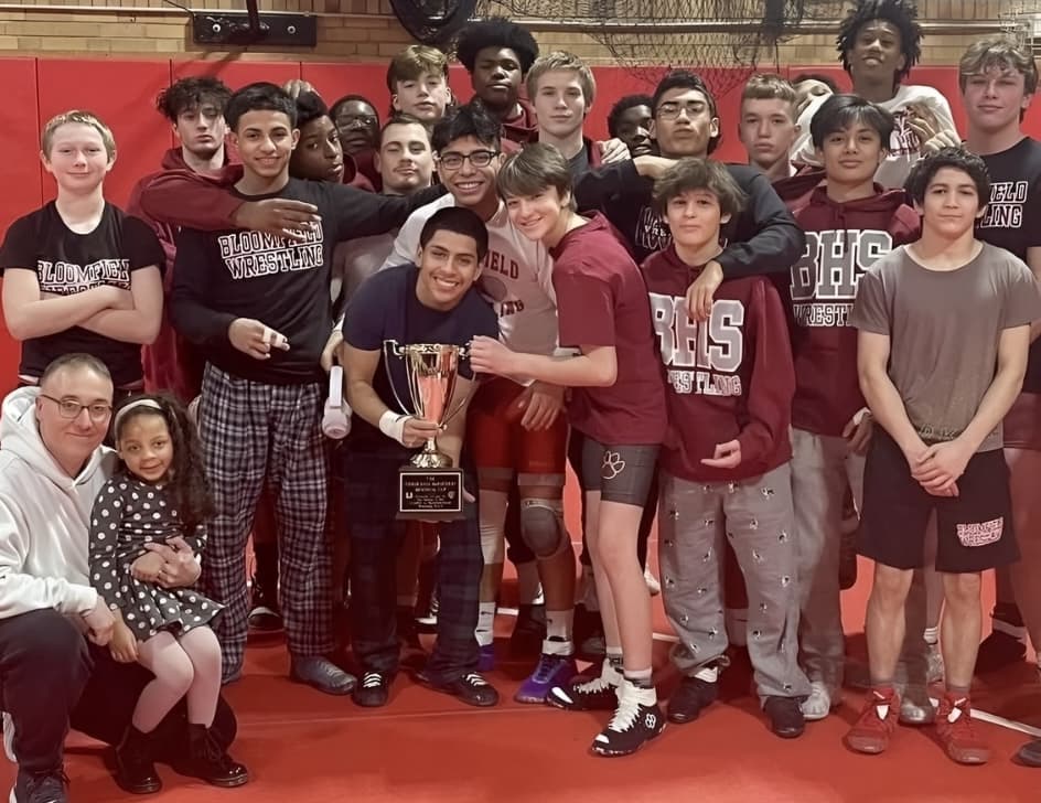 Wrestling team holding trophy